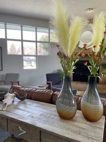 three vases on a table with flowers in them